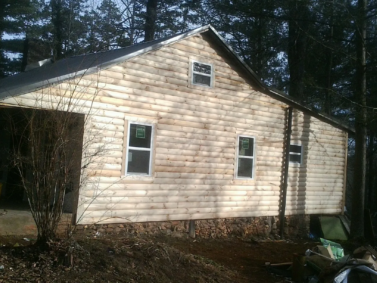 New log siding and dark metal roofing on a gable end in Marina