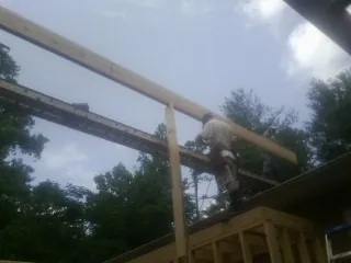 Carpenter setting a ridge beam over a new addition frame — Ice Dam Removal by Roofing Brothers in Marina
