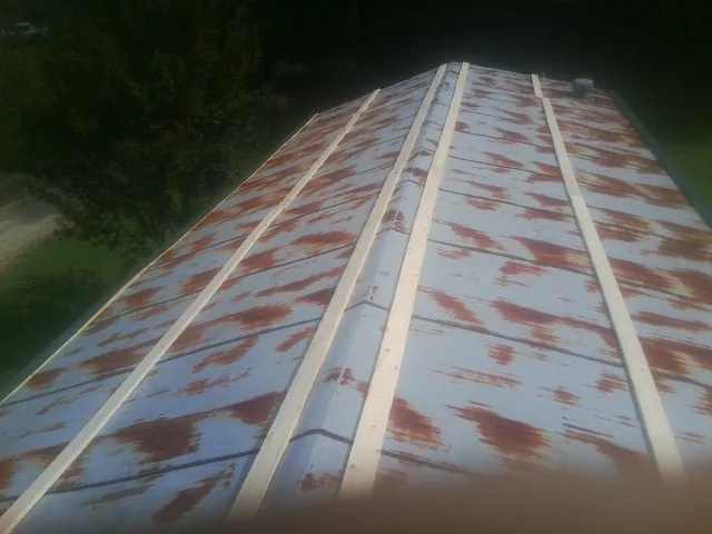 Rusted metal roof panels with new wood purlins before replacement — Storm Damage Roof Repair in Marina by Roofing Brothers