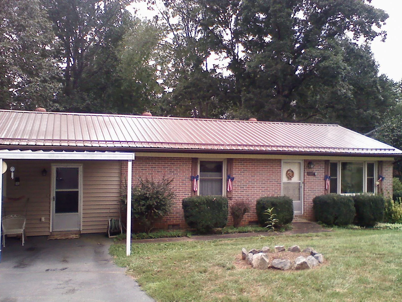 Bronze metal roof and carport on a brick ranch home — Roof Repair work by our crew in Marina