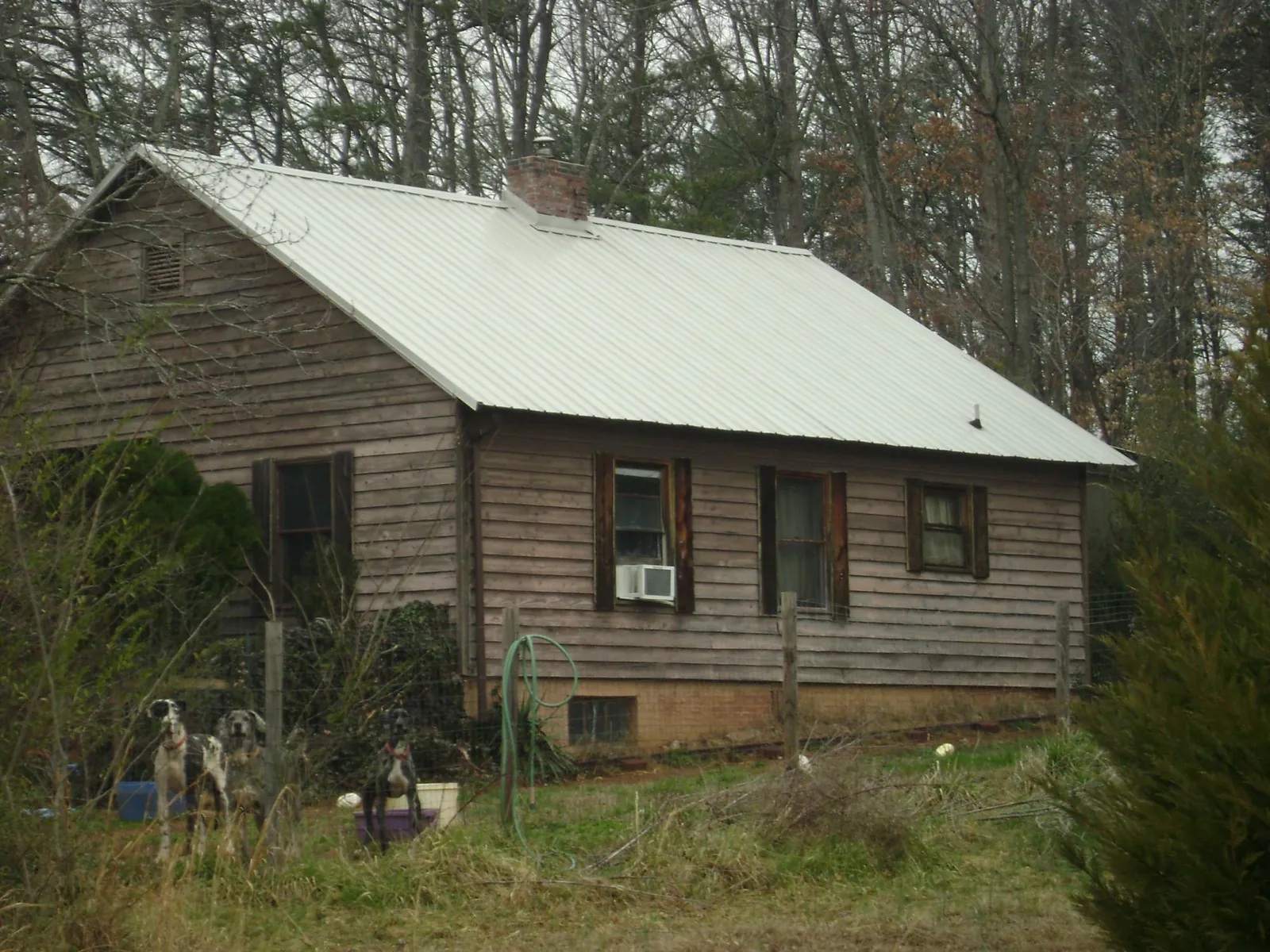 White metal roof on an old wood sided farmhouse, from a Metal Roof Installation job in Marina